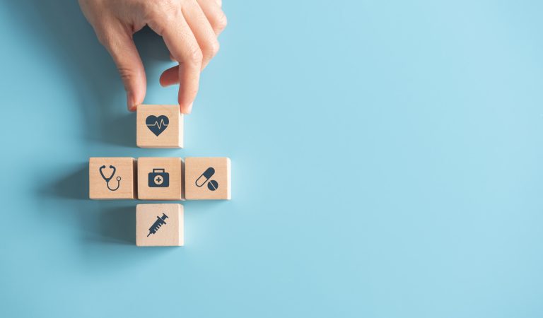Health Insurance Concept, Hand of woman arranging wood cube stac